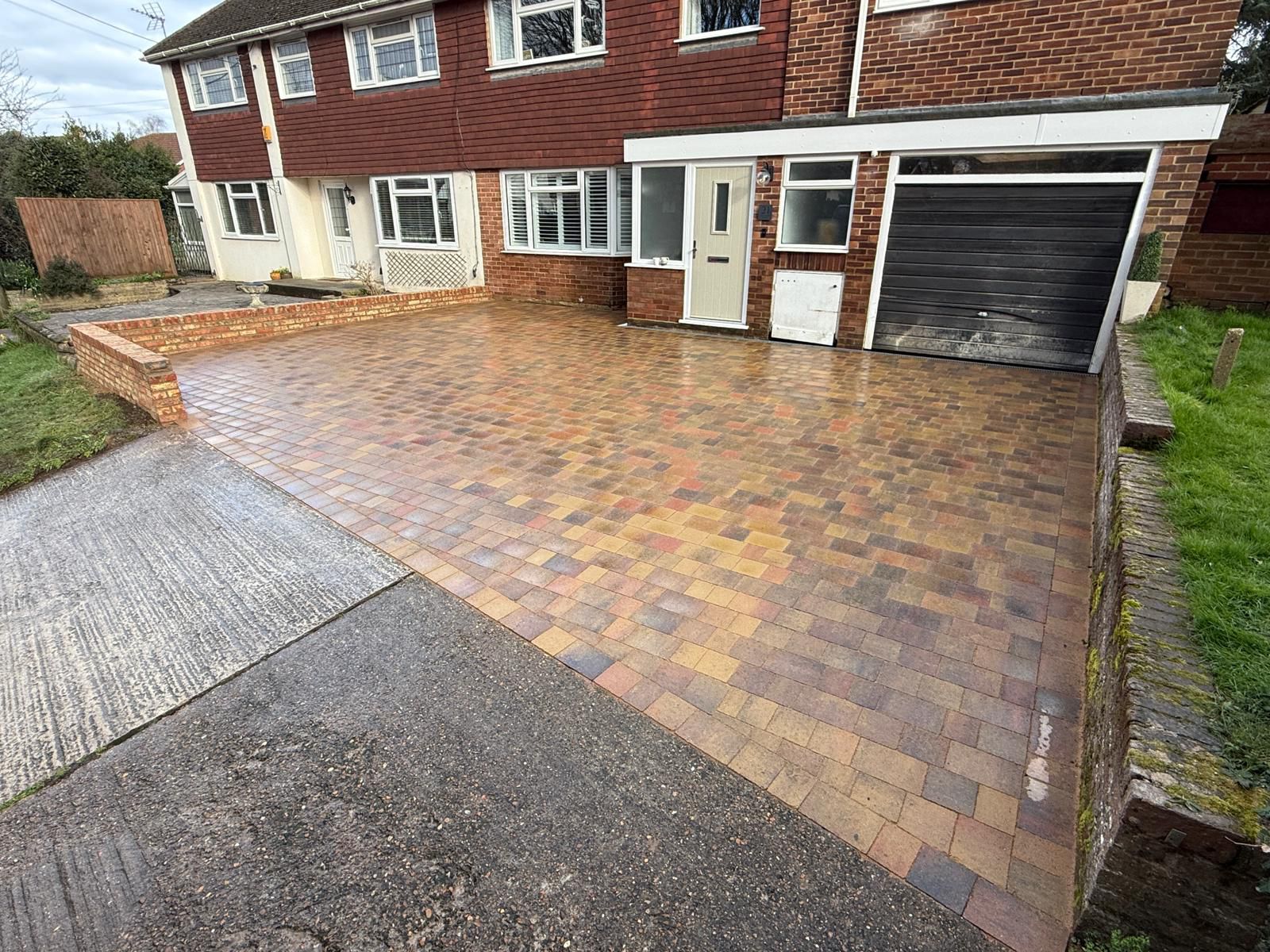 Brindle block paving driveway with brick wall, viewed towards the house