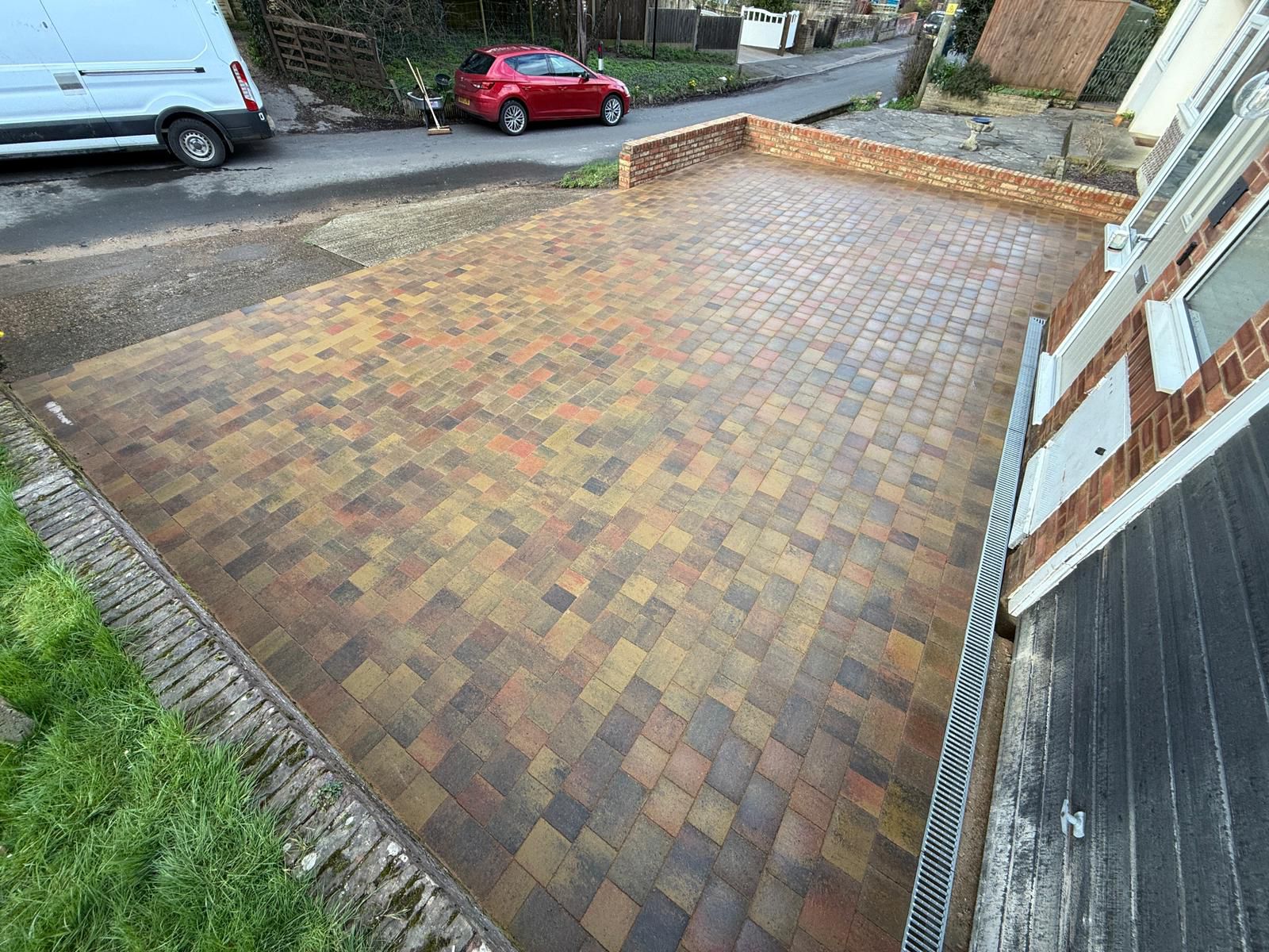 Close-up of brindle block paving and brick wall edge