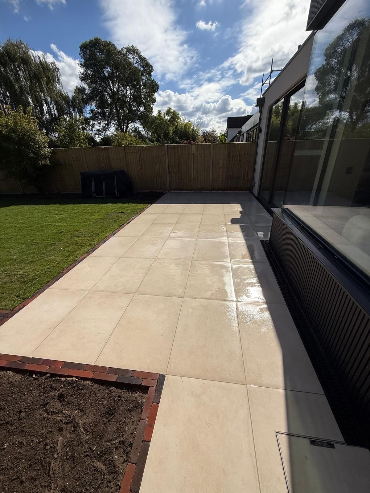 Porcelain patio beside a new lawn and fence