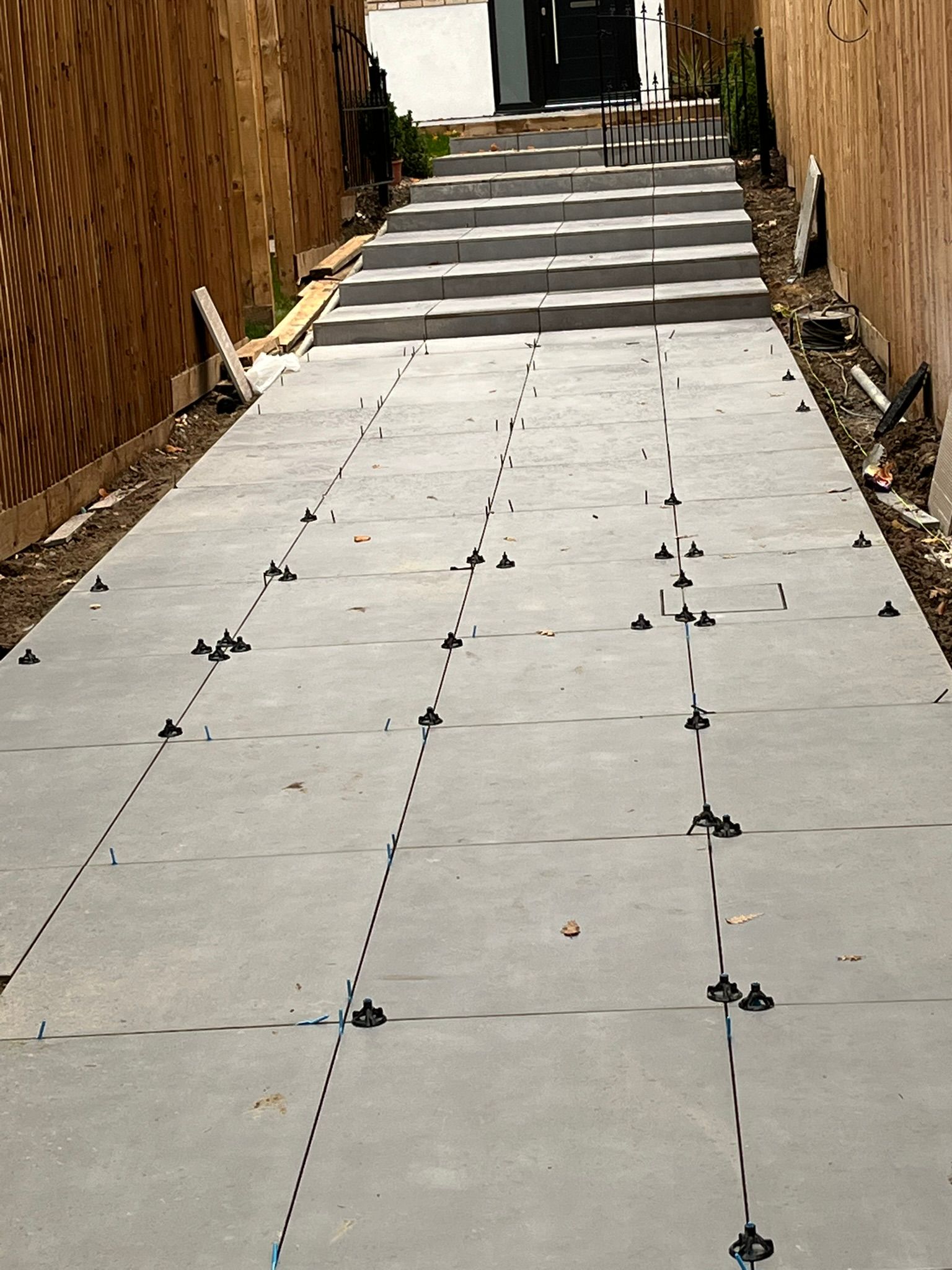 Porcelain patio slabs being laid with levelling spacers