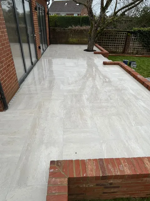 Large pale porcelain patio along the back of a house