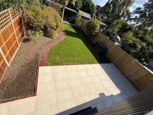 Sandstone patio and path with lawn and fencing