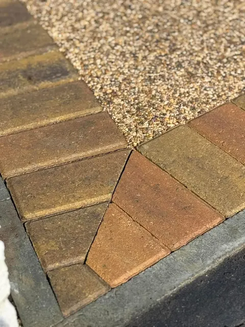 Close-up of block paving border meeting aggregate surface