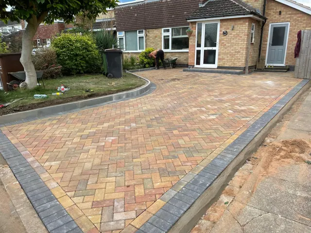 Buff block paving driveway with curved charcoal border