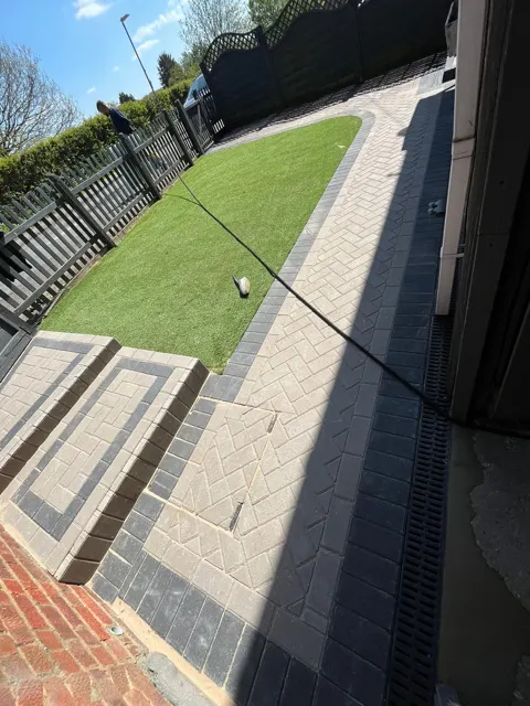 Paved garden path and steps beside artificial grass