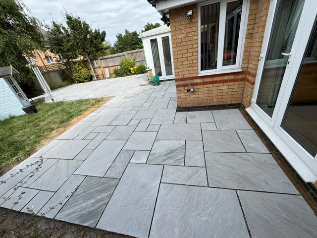 Large grey porcelain patio at the back of a house